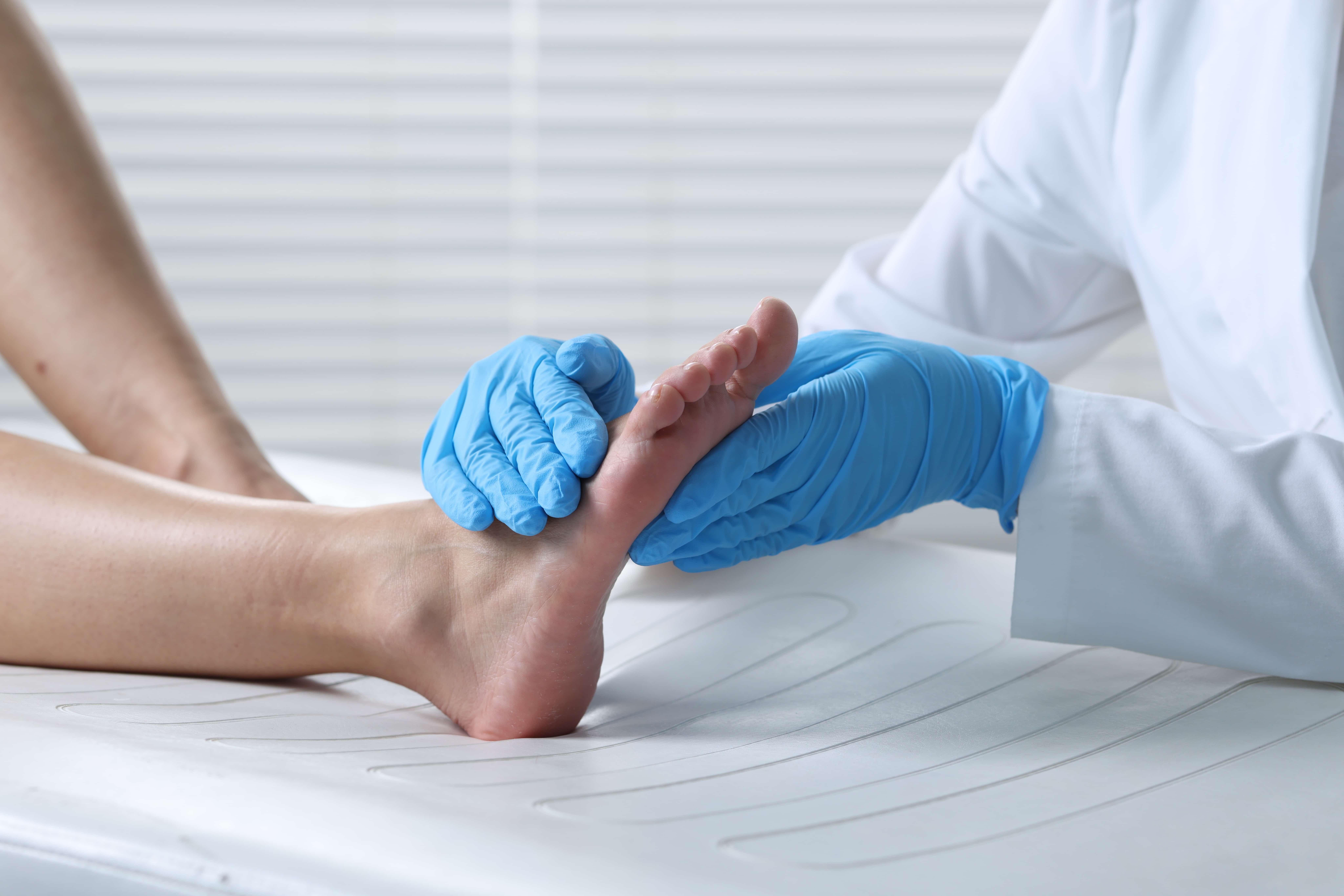 Foot wrapped in bandage. A first aid procedure with bandages and aid provided to injuries and damage. Care of injured persons in accidents. Doctor examining patient's foot in hospital, closeup